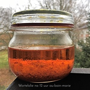 glazen weckpot met diep oranje wortelolie jaminsoapstudio - tekst: Wortelolie na 12 uur au-bain-marie