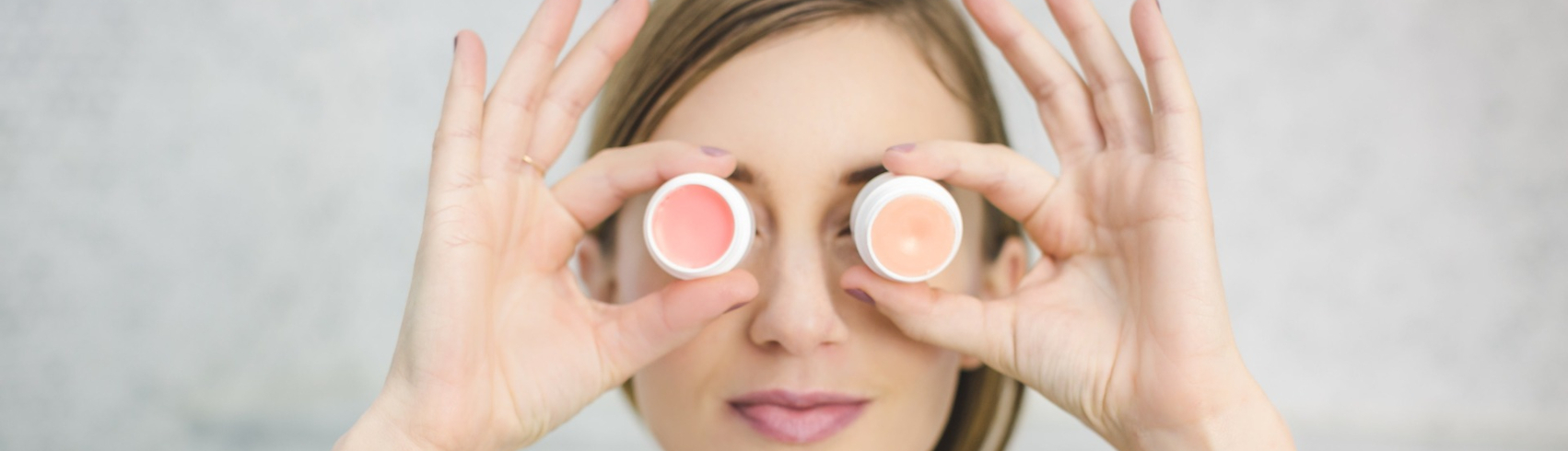 vrouw met lippenbalsempotjes voor ogen